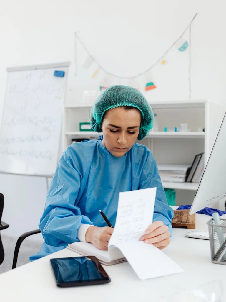 Mesa editorial con revistas médicas encuadernadas, lupa y pluma estilográfica